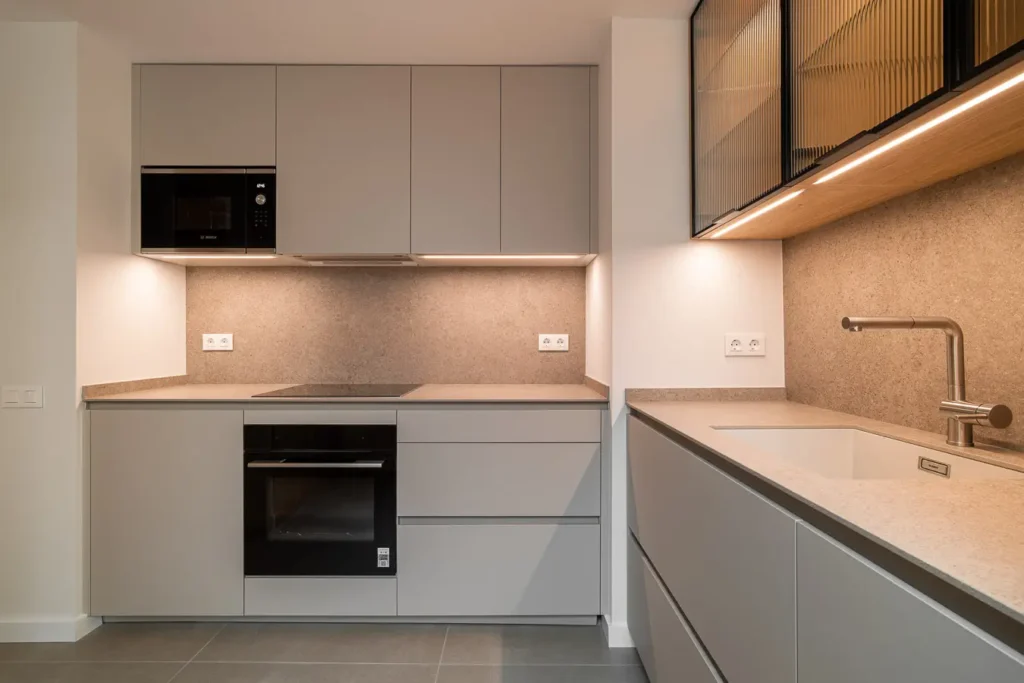 zona de coccion y almacenaje en cocina minimalista con acabados grises