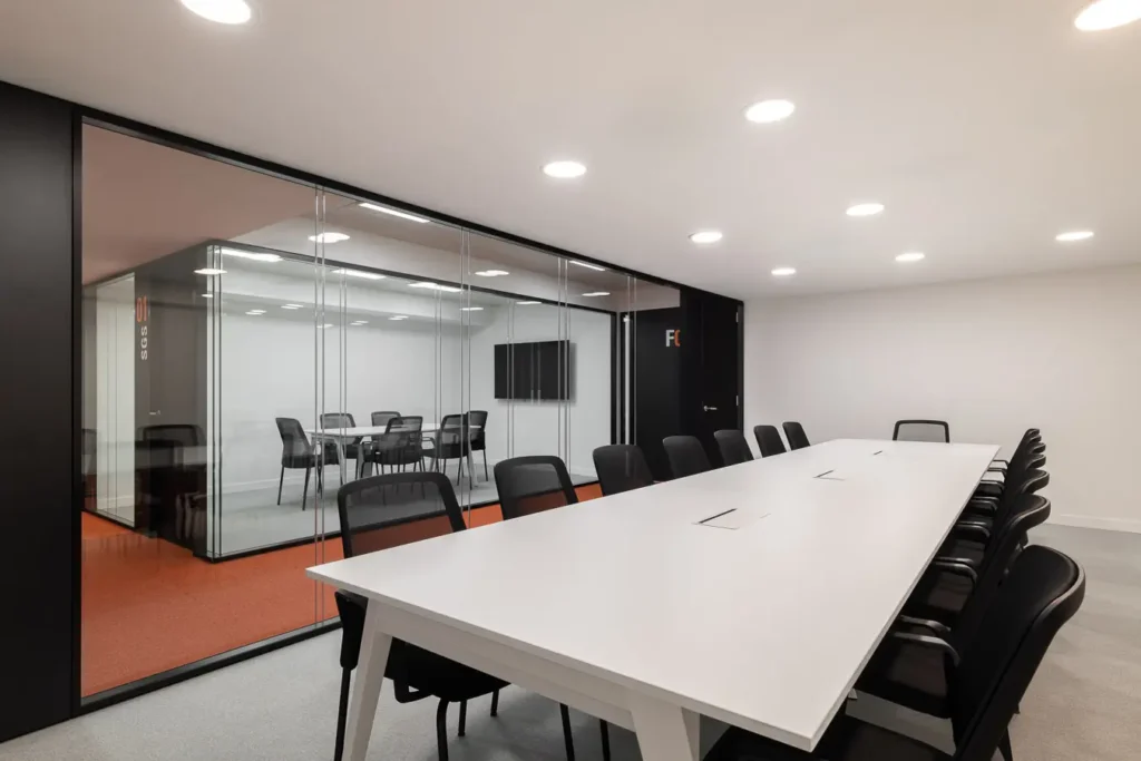 sala juntas cristal mesas blancas sillas negras