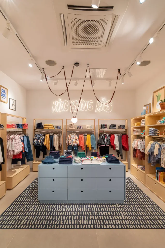 interior de tienda infantil con letrero kids being kids iluminado