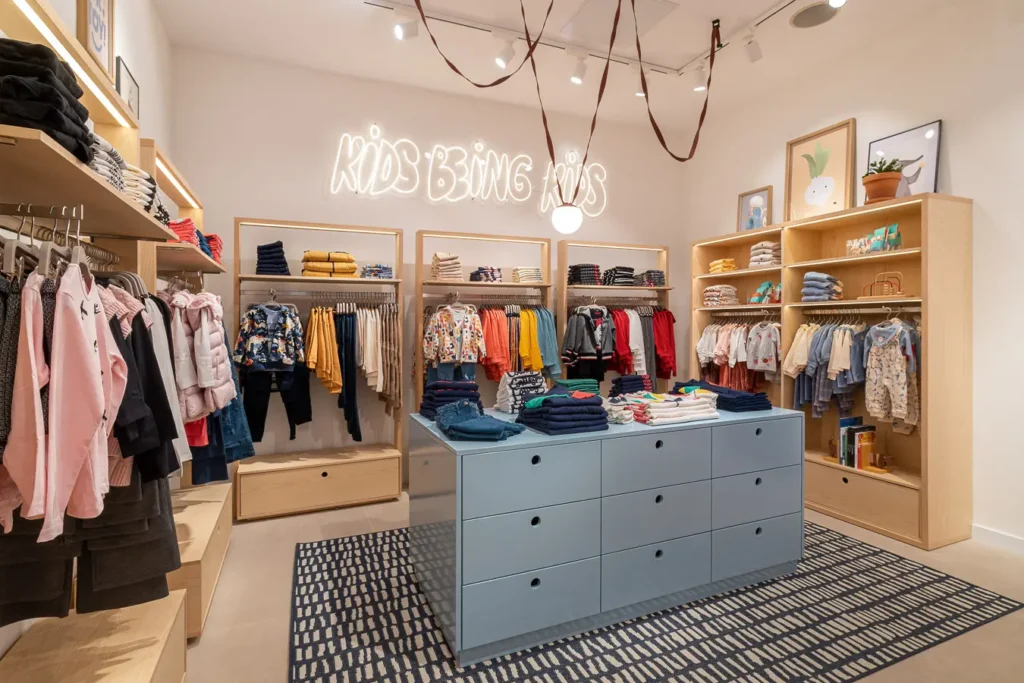 tienda infantil moderna con muebles azules y estantes de ropa