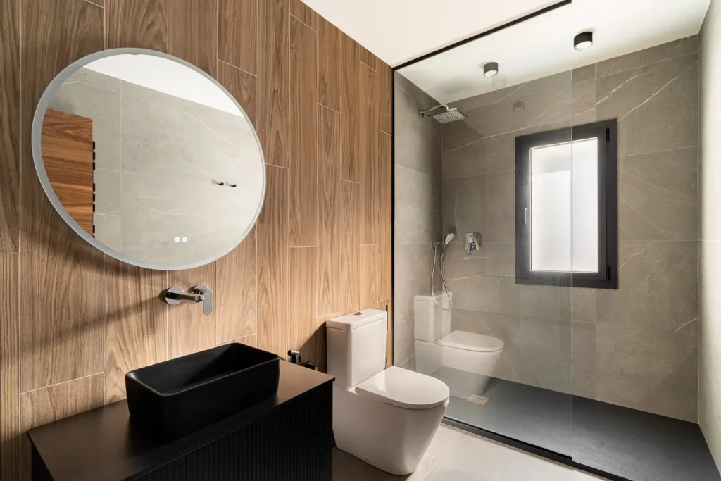 bano moderno con ducha de vidrio y lavabo negro rectangular