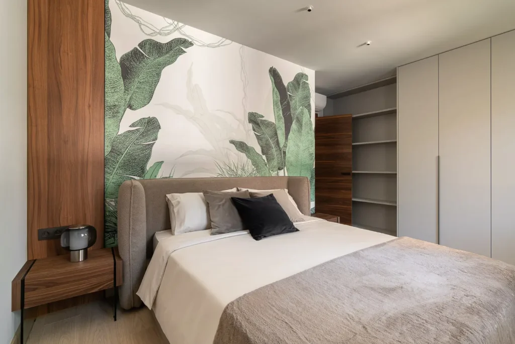 dormitorio con mural de hojas verdes y cama doble elegante