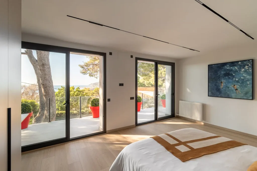 dormitorio luminoso con vistas al mar y puertas de cristal