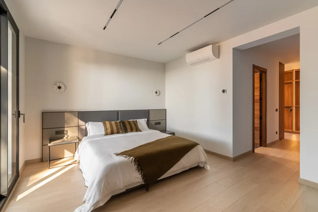 dormitorio moderno con cabecera gris y manta marron