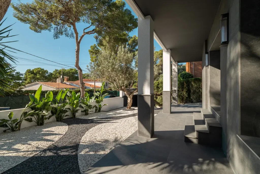 entrada principal con jardin minimalista y camino de piedra bicolor