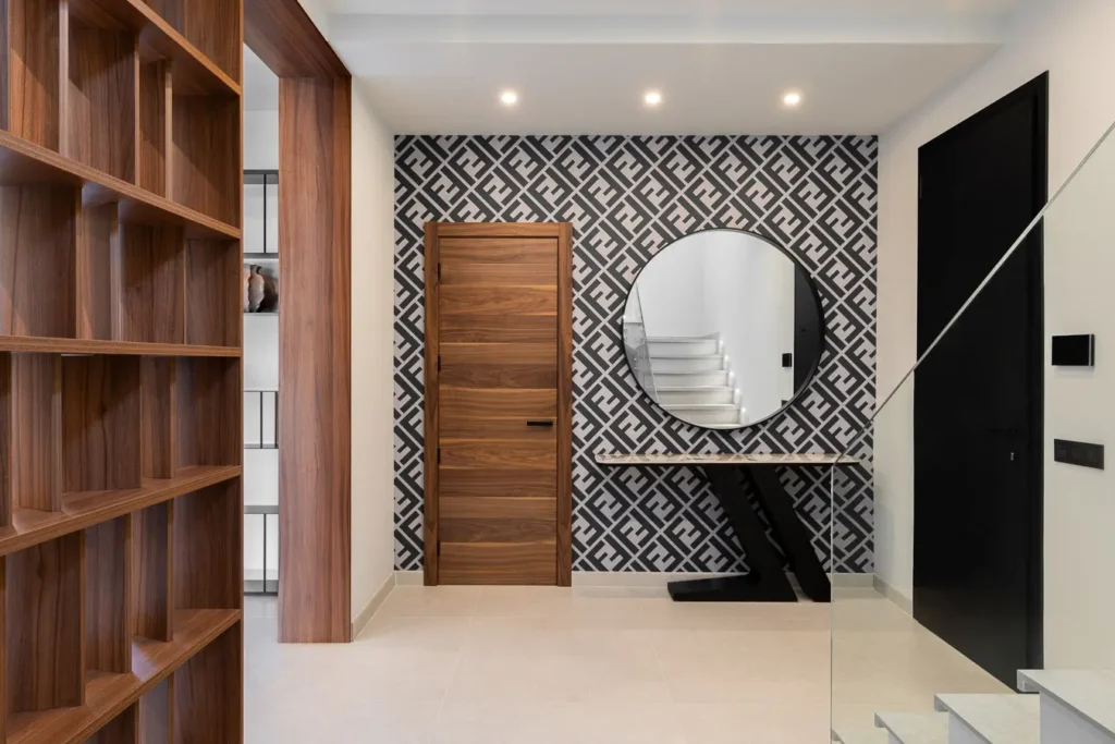 recibidor elegante con papel pintado geometrico y espejo redondo