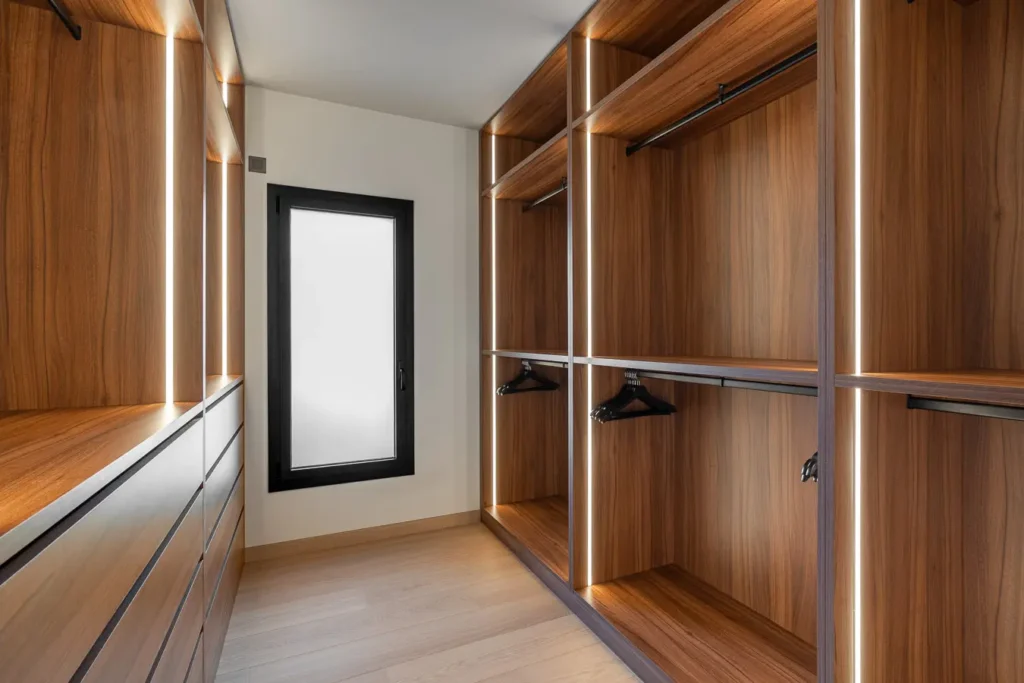 vestidor con armarios de madera iluminados y ventana esmerilada
