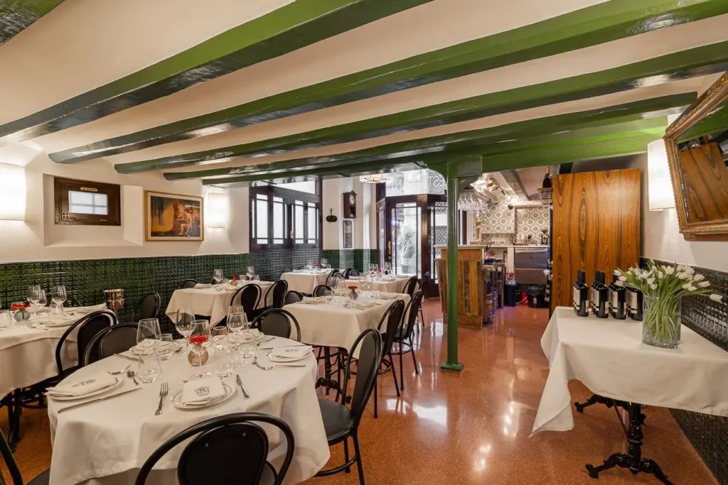 comedor de restaurante con mesas elegantes y vigas verdes