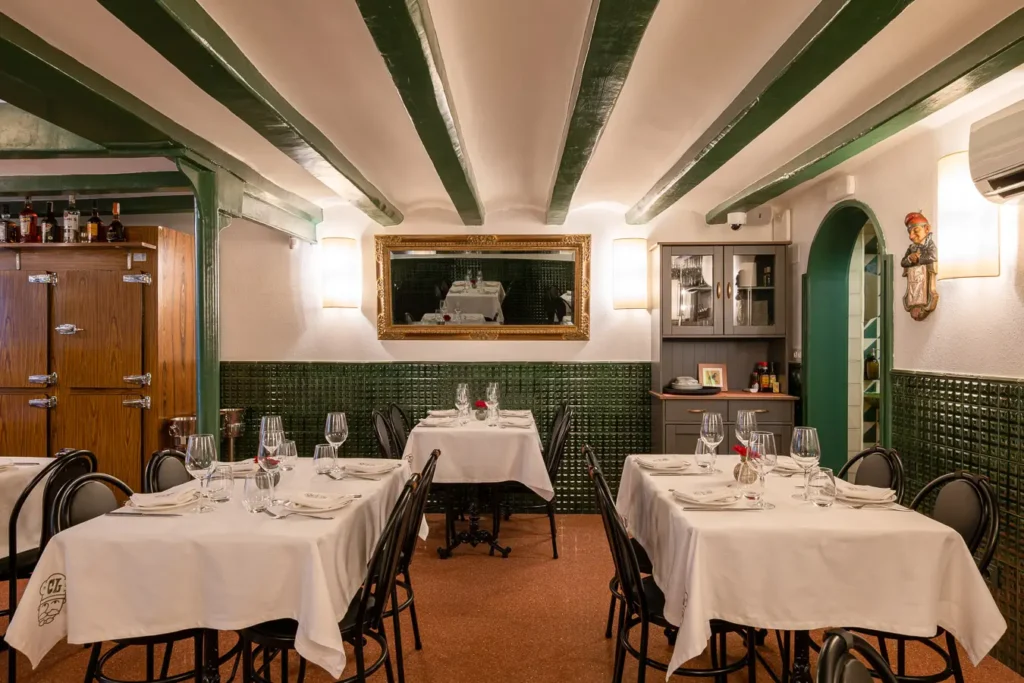comedor intimo con vigas verdes y espejo dorado
