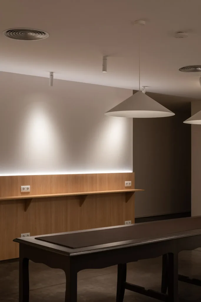 lamparas colgantes y mesa en sala minimalista de trabajo