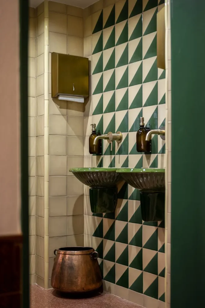 lavabo con azulejos verde esmeralda y detalles de laton