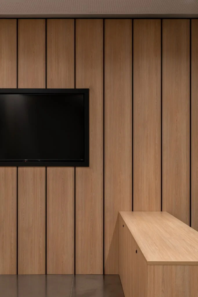 pantalla en pared de madera junto a mesa de presentacion