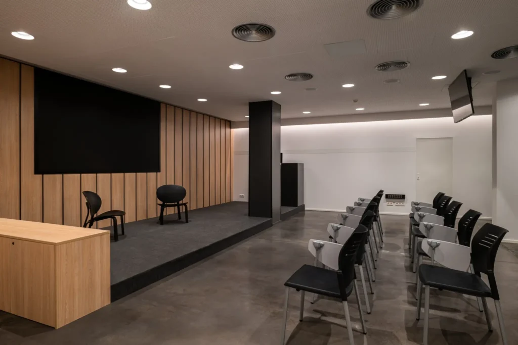sala de conferencias con escenario y sillas organizadas