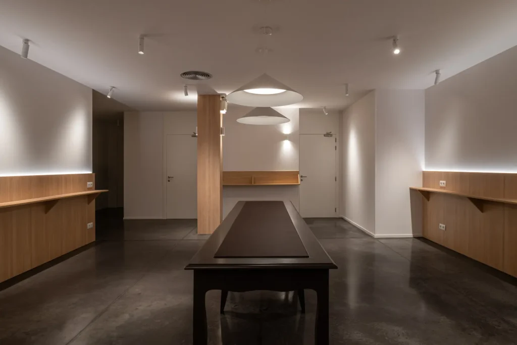 vista amplia de sala con iluminacion tenue y escritorios