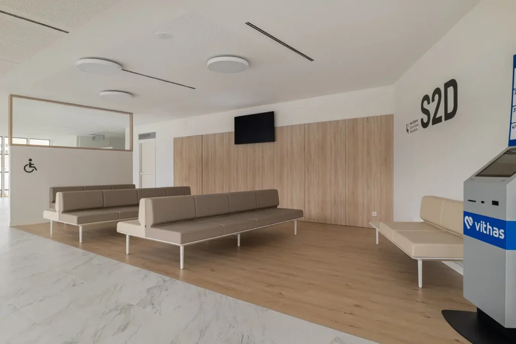 sala espera hospitalaria con bancos modulares y paneles de madera