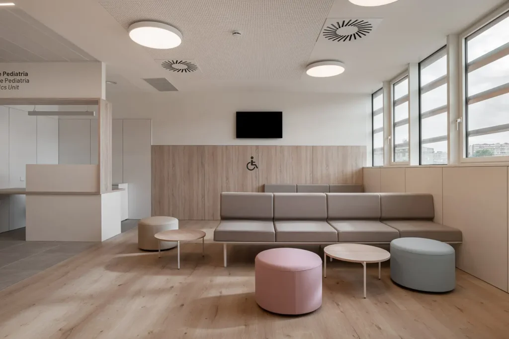 sala espera pediatria con pufs colores pastel y mesas bajas