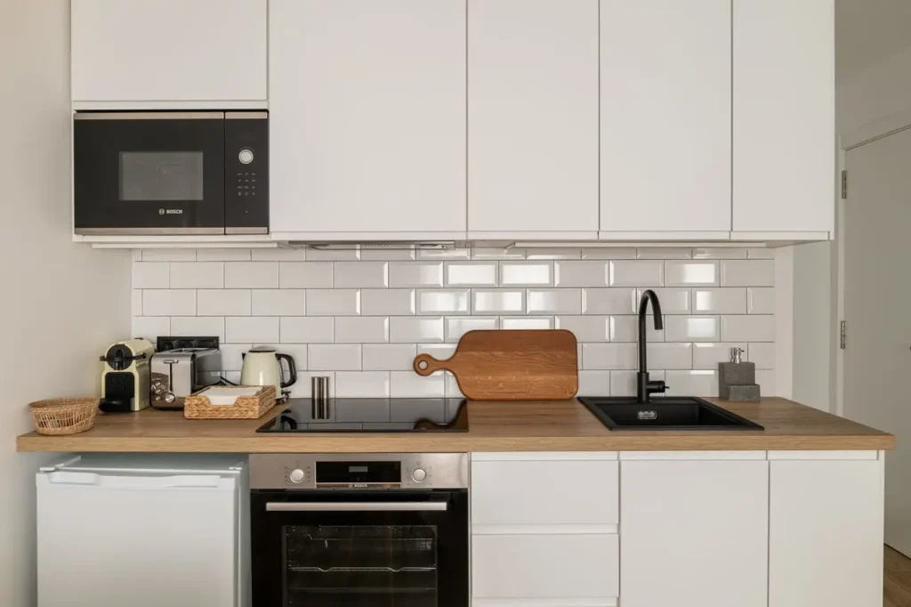cocina moderna blanca con encimera de madera y electrodomesticos