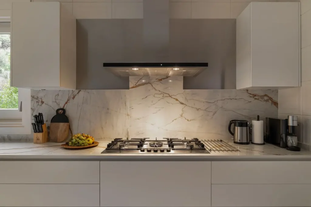 cocina moderna con placa de coccion y salpicadero de marmol