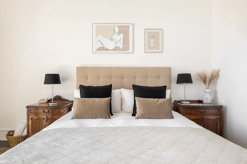 dormitorio elegante con cabecero tapizado y mesillas de madera