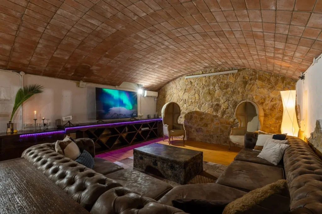sala de estar con sofas de cuero y techo de boveda rustico