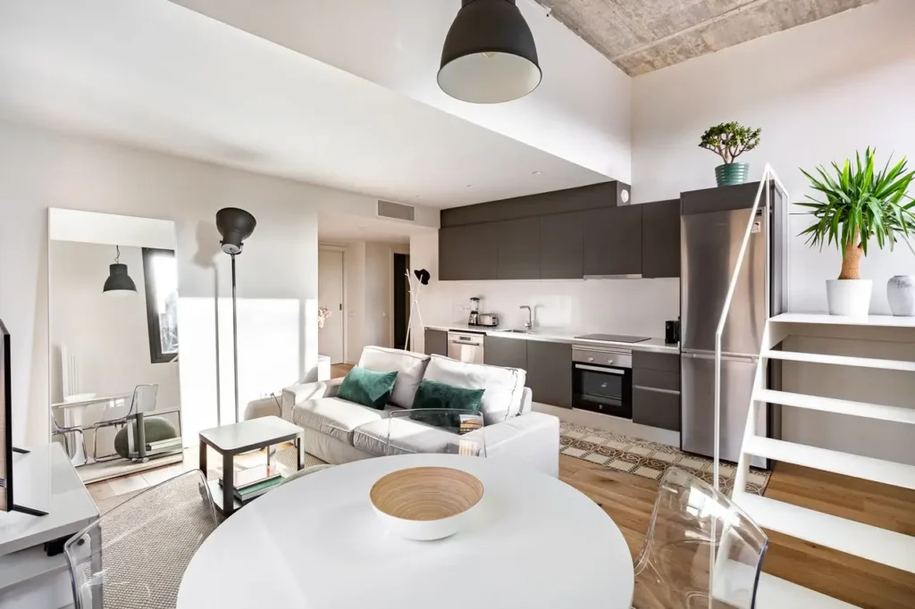 salon moderno con cocina abierta sofa blanco y escalera interior