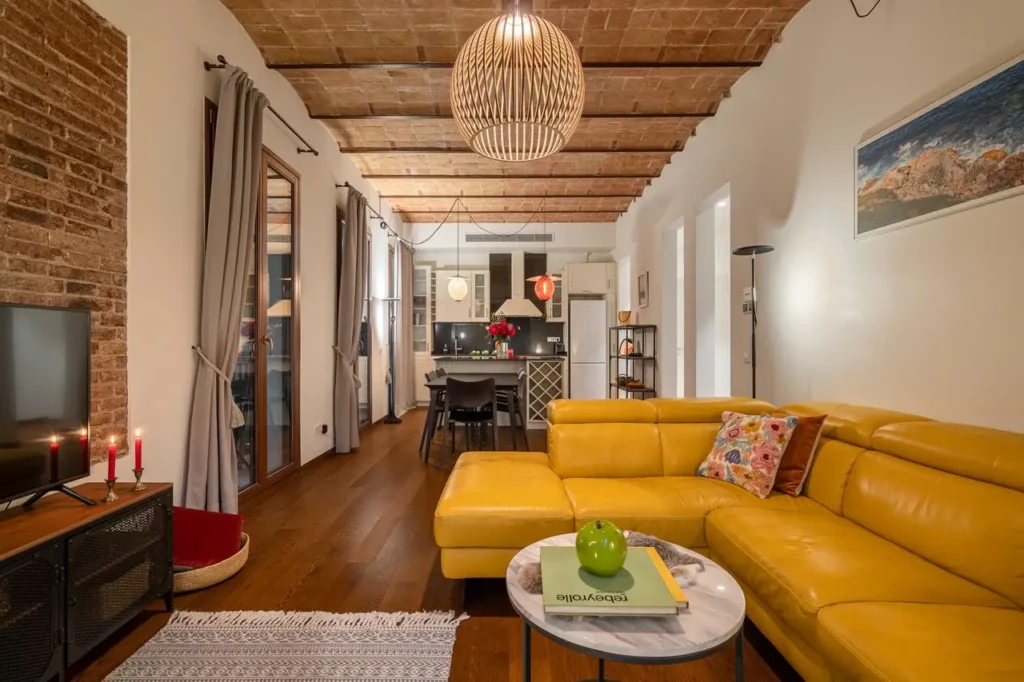 salon moderno con sofa amarillo y cocina abierta estilo industrial