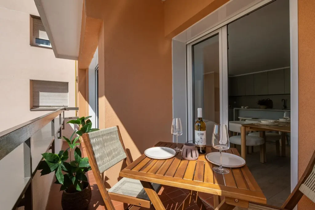 balcon apartamento mesa madera vino copas comedor exterior