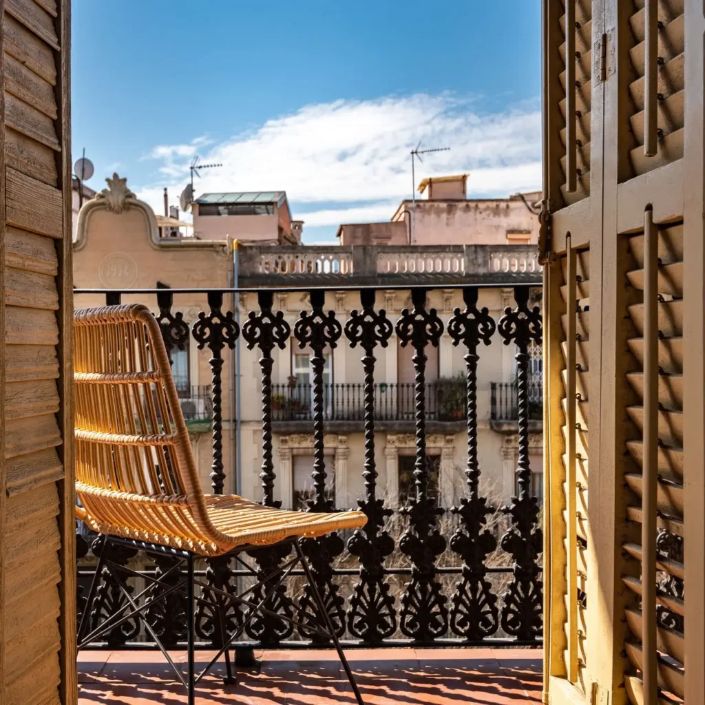 balcon urbano silla mimbre vistas edificios cielo azul