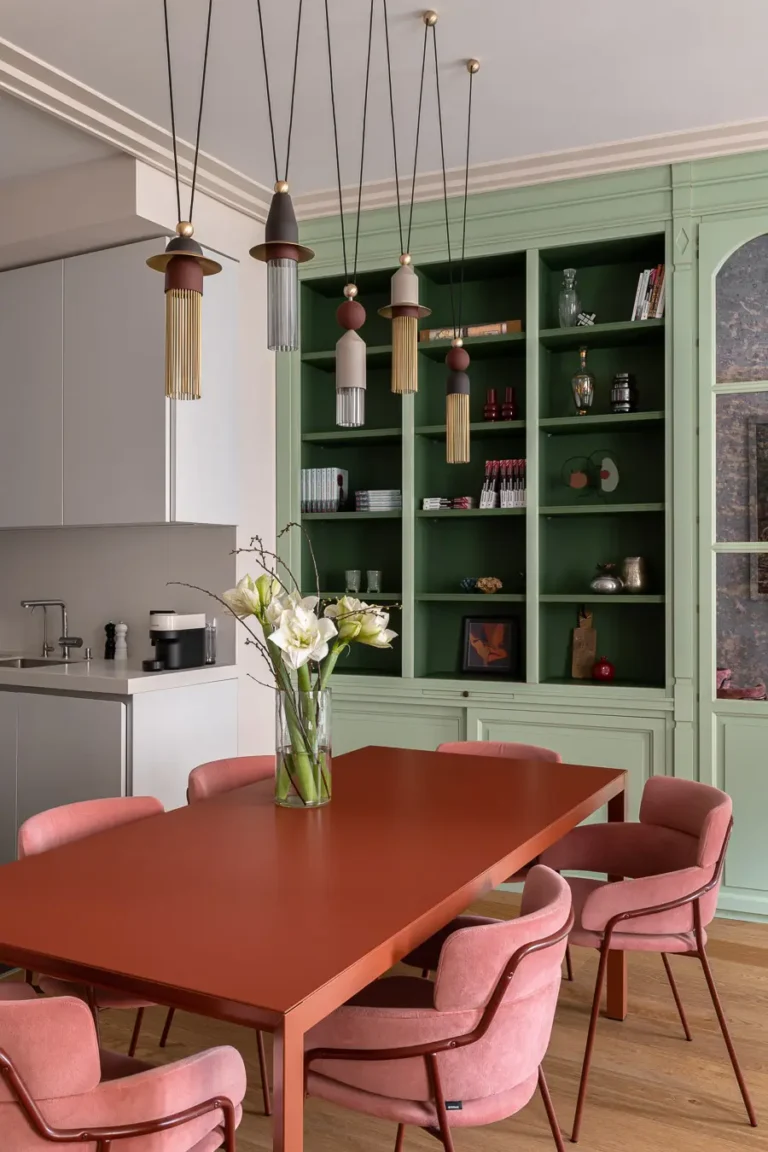 comedor moderno con mesa roja y sillas tapizadas rosas
