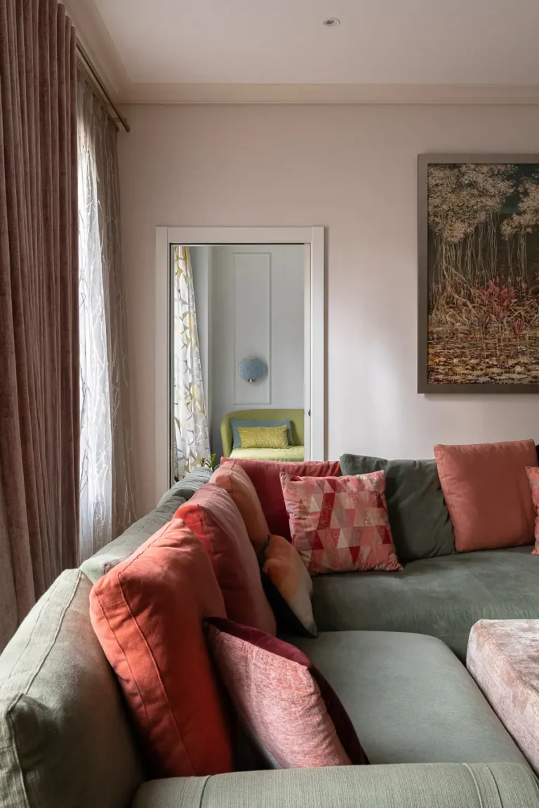 detalle de sofá con cojines de colores y vista a habitación contigua