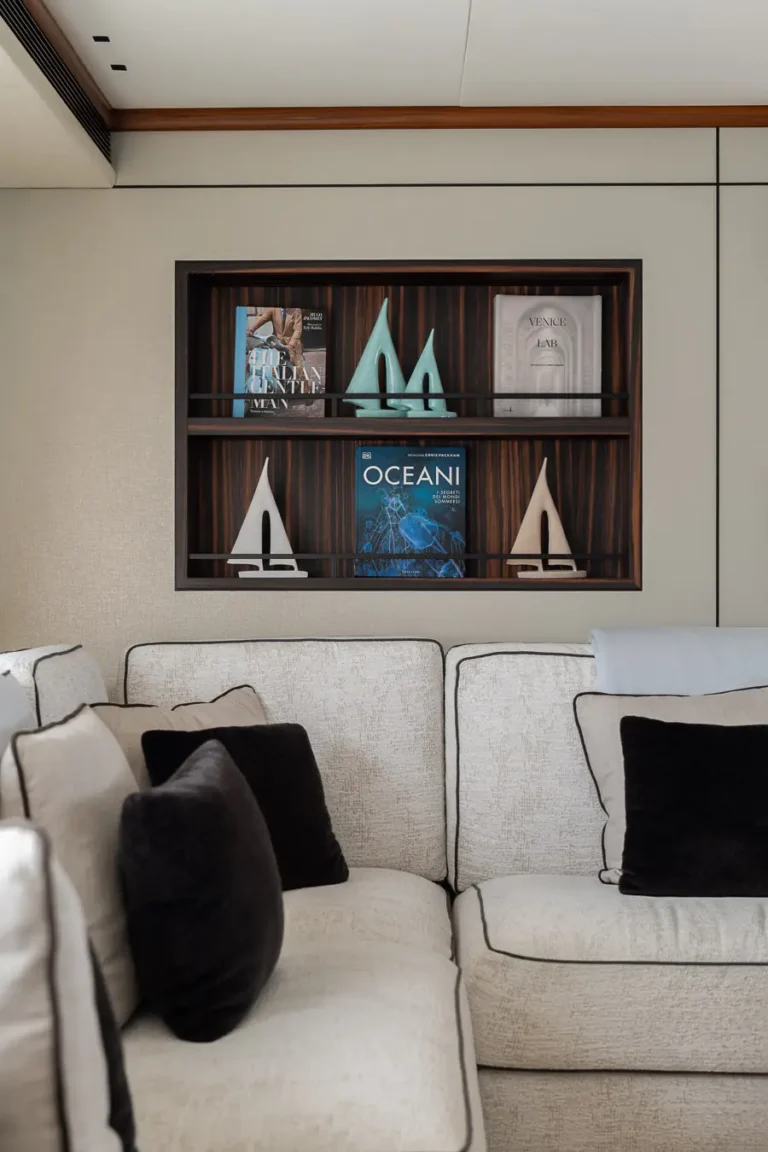 estanteria empotrada con libros y decoracion sobre sofa claro