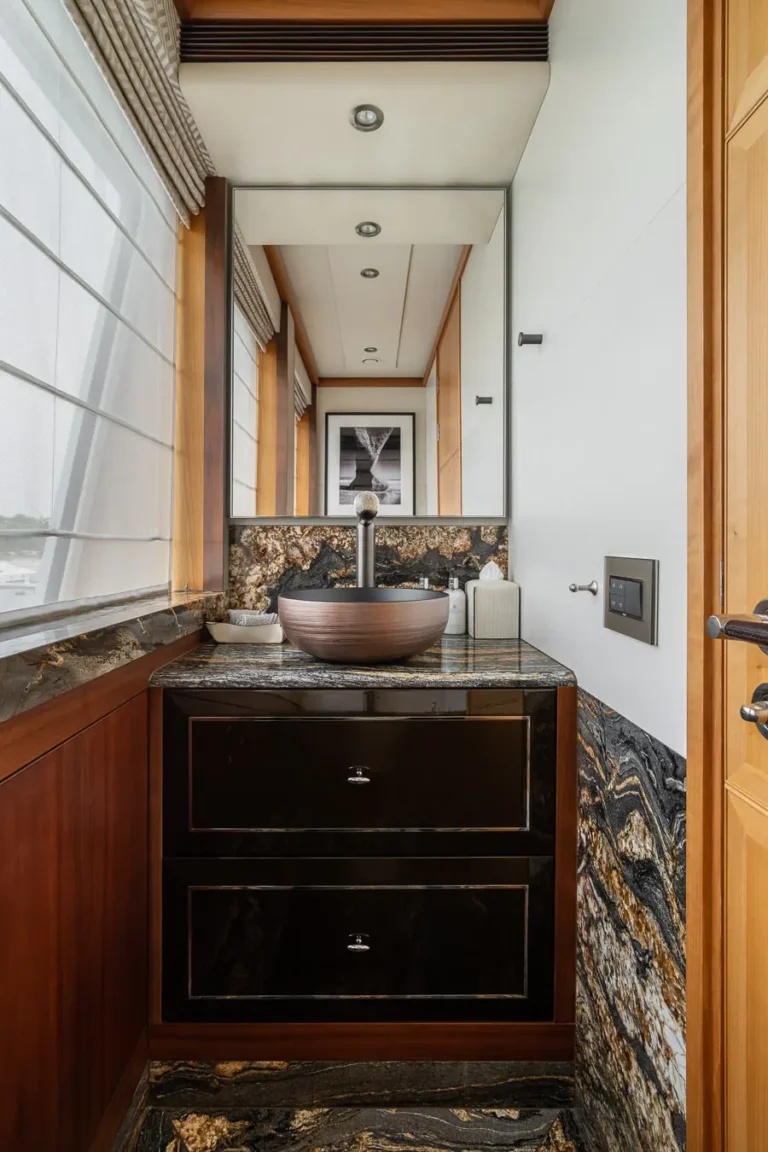 lavabo moderno con encimera de piedra y espejo en bano compacto