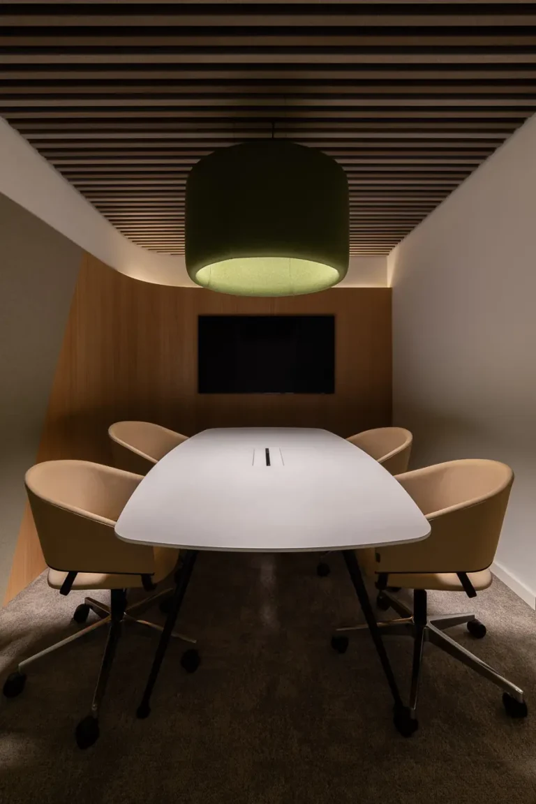 mesa de reuniones moderna con sillas tapizadas y techo de lamas