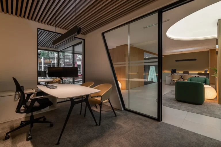 oficina contemporanea con escritorio y vista a sala de espera