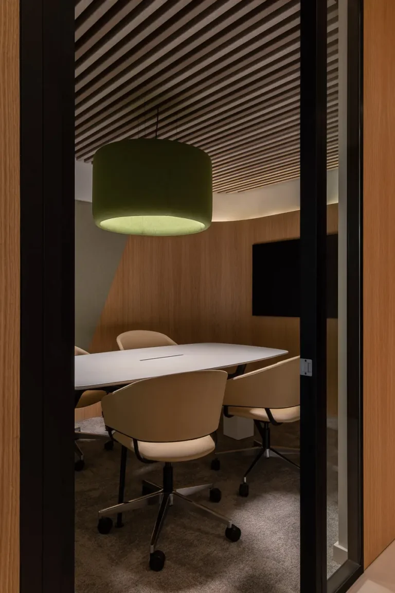sala de reuniones con lampara colgante verde y mesa blanca