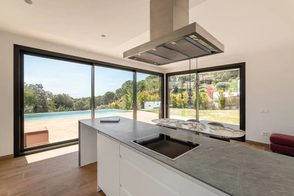 cocina moderna con isla y vistas a piscina infinita