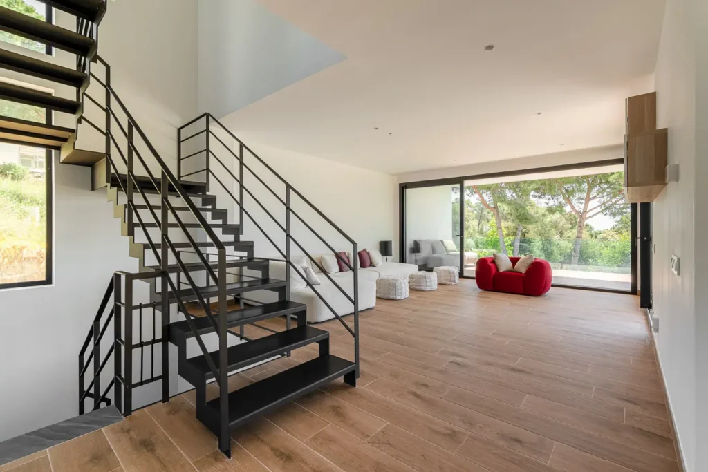 salon moderno con escalera abierta y grandes ventanales