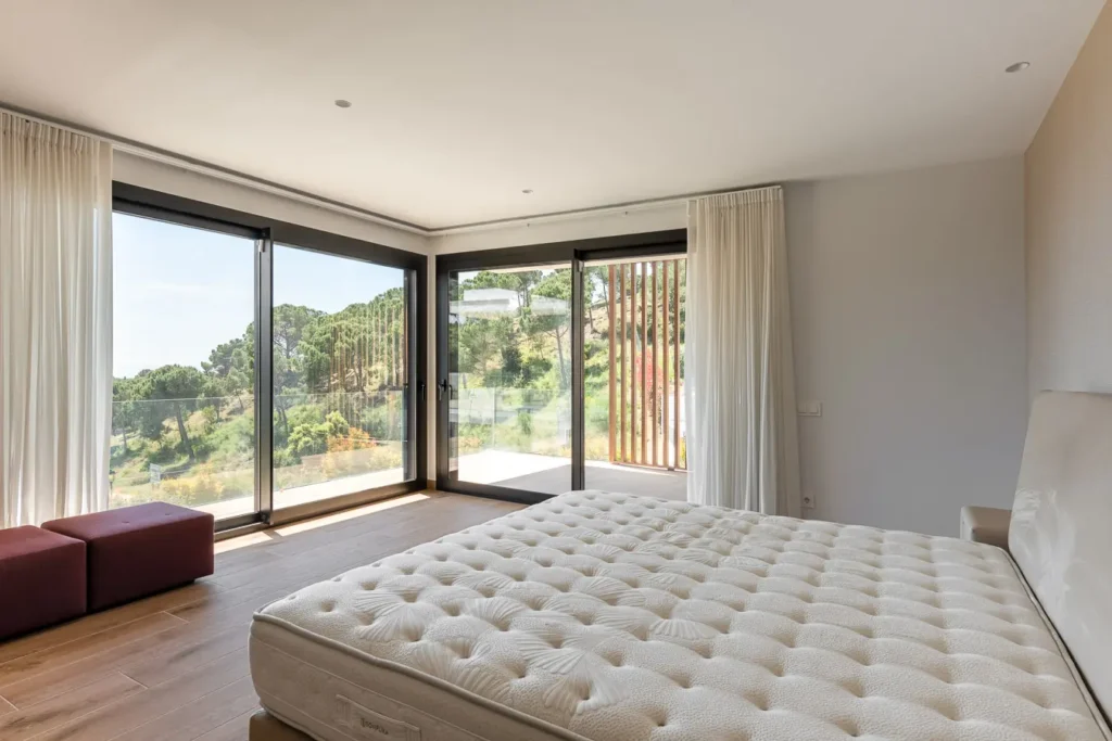 suite principal con ventanales y vistas naturales