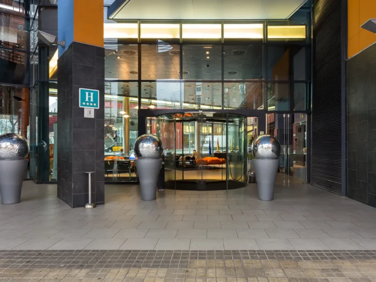 acceso principal hotel con puerta giratoria y esferas decorativas