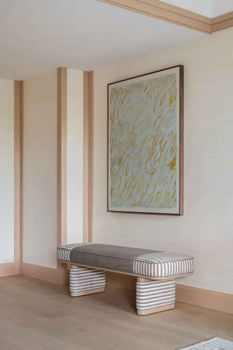 banco tapizado y arte abstracto en suite de hotel