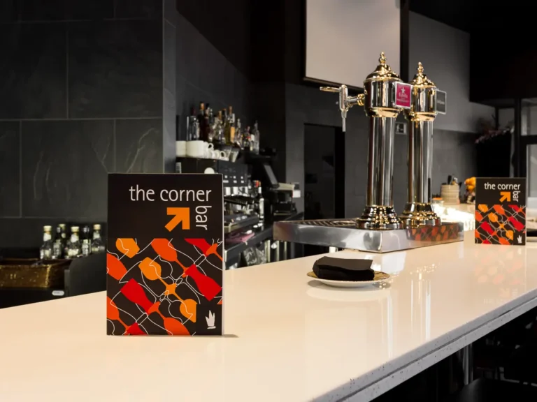 barra hotel con grifos de cerveza y cartel the corner