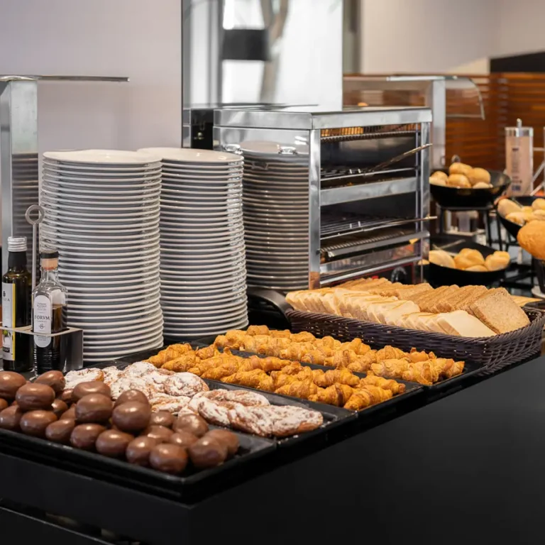 buffet de hotel con bolleria pan y platos