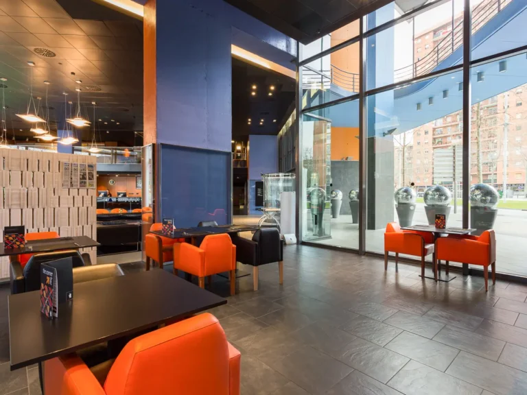 cafeteria hotel con sillones naranjas y ventanales