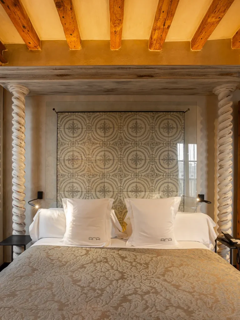 cama doble hotel cabecero azulejos columnas talladas