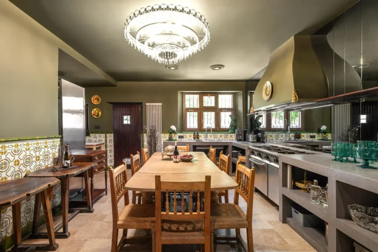 cocina amplia con mesa de madera azulejos artesanales y lampara