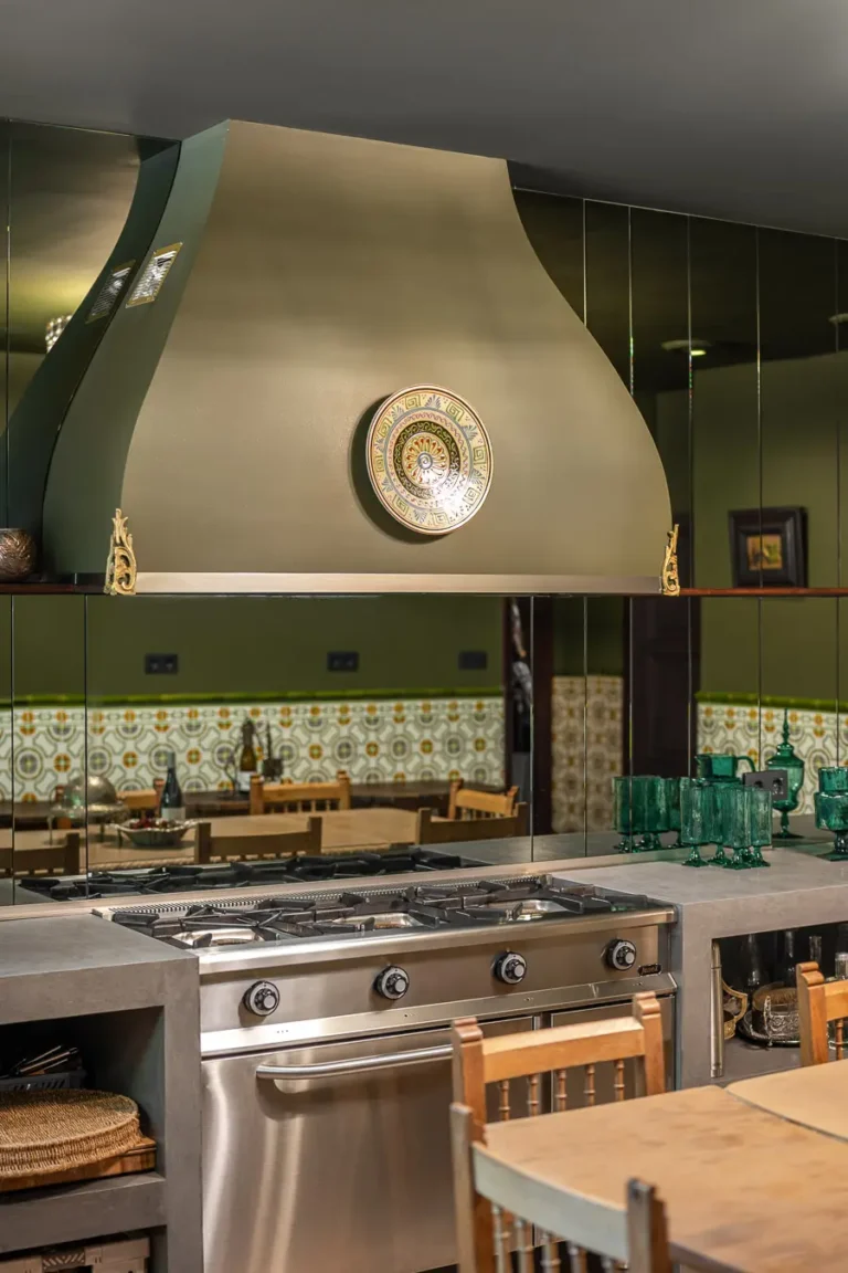cocina con campana extractora verde fogones y vasos de cristal