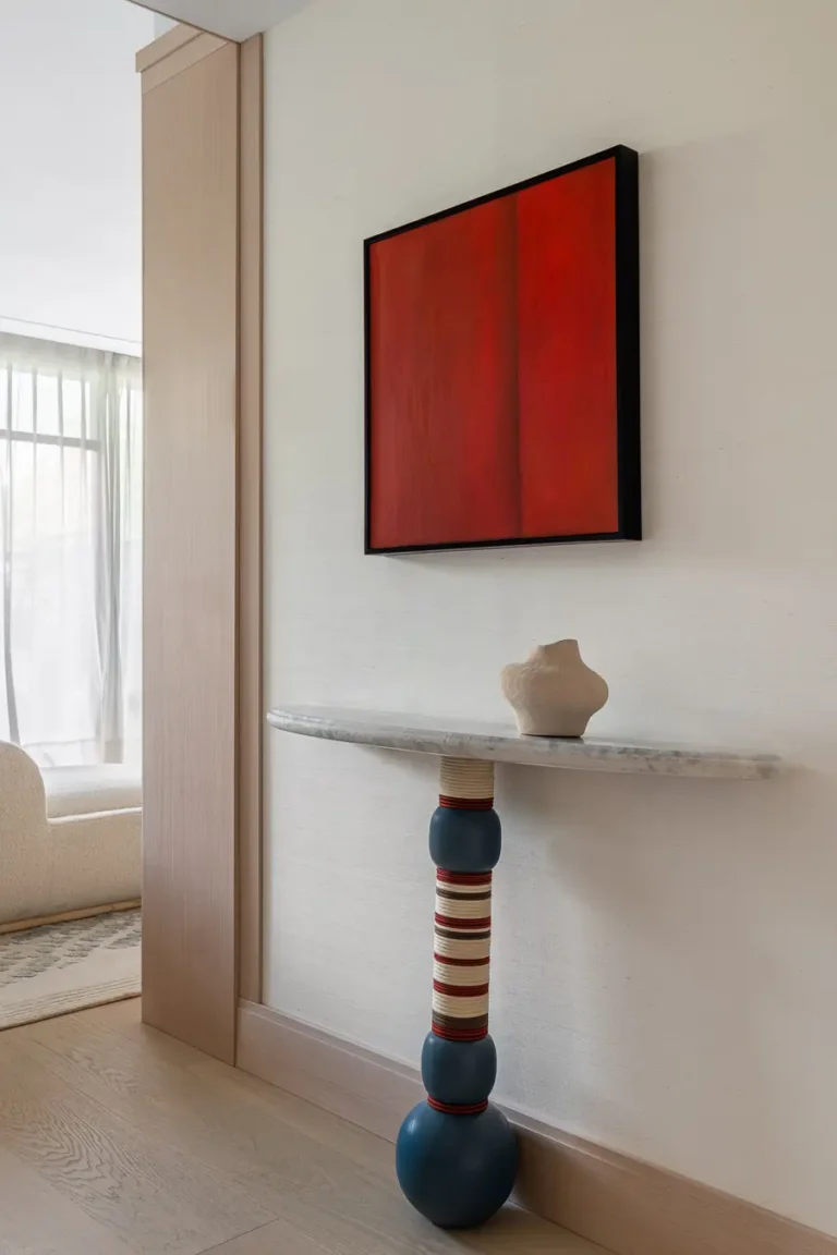 consola decorativa con cuadro rojo en habitacion de hotel
