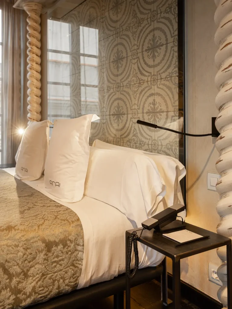 detalle cama almohadas lampara lectura hotel
