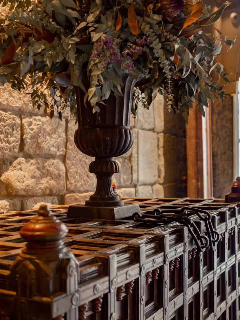 detalle de jarron con flores sobre arcon de madera antigua
