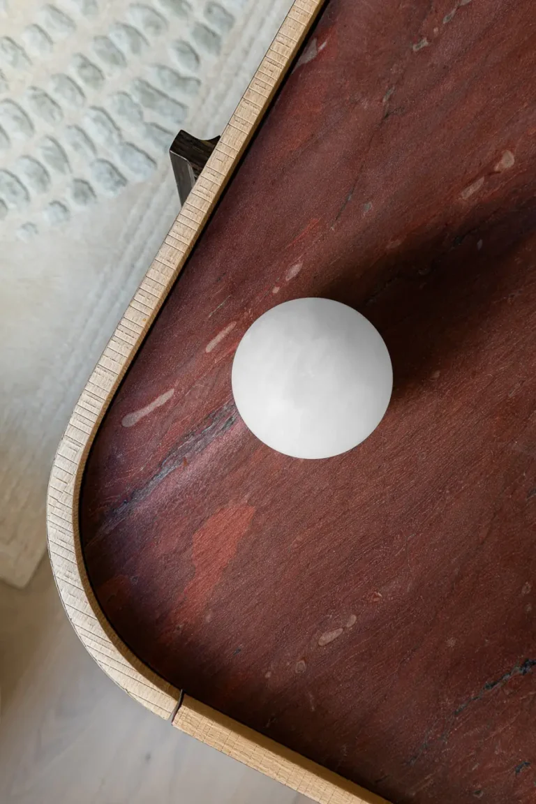 detalle de mesa de piedra roja y esfera decorativa